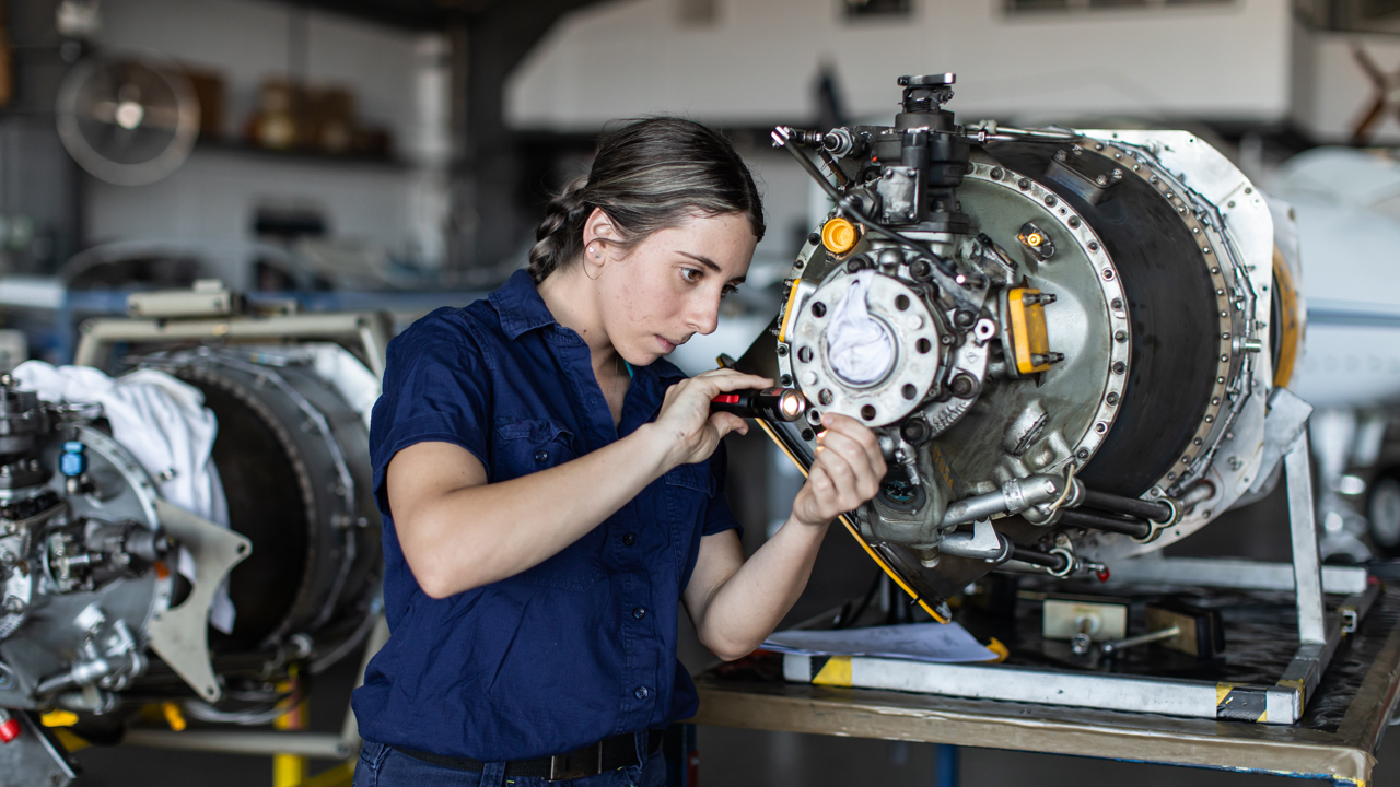 An engineering technician in a workshop working on a piece of machinery