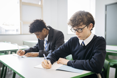 Two secondary school boys working at their desk