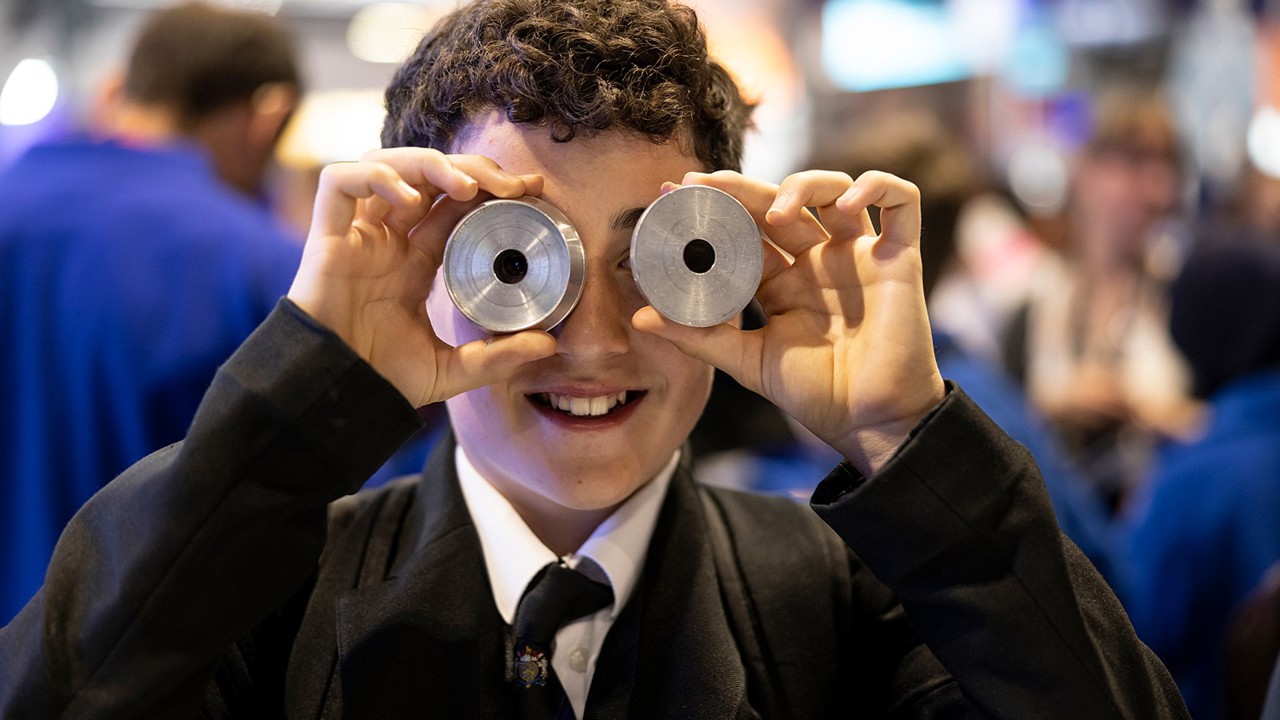 A young person interacts with exhibits and stands and activities at The Big Bang Fair