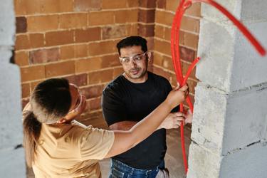 Two engineers working at a building site studying the construction materials