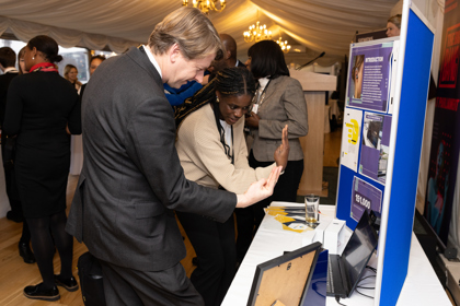 Ranita Ariyibi, UK Young Engineer of the Year 2023 shows a guest at The Big Bang at Parliament her invention