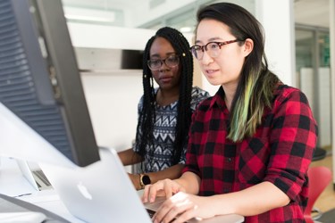 Two business professionals working at a computer