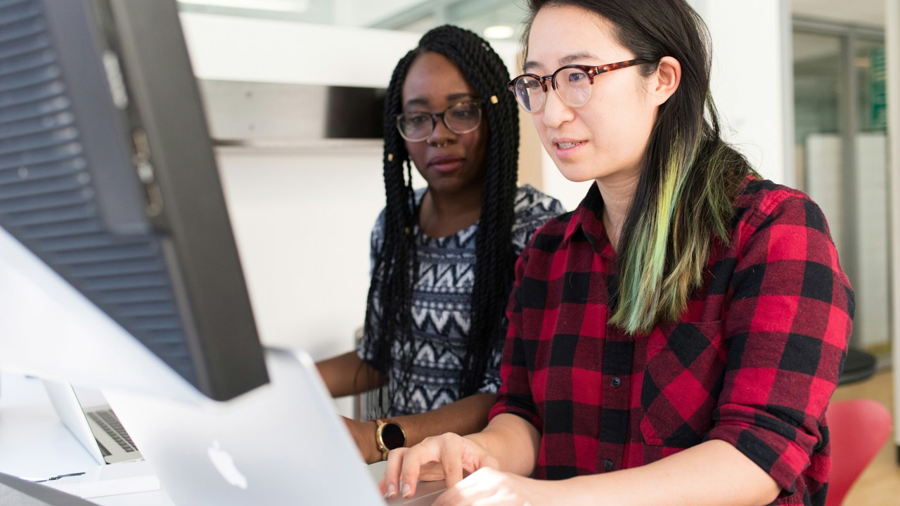 Two business professionals working at a computer