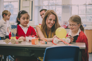 Primary school students doing hands-on experiment with teacher