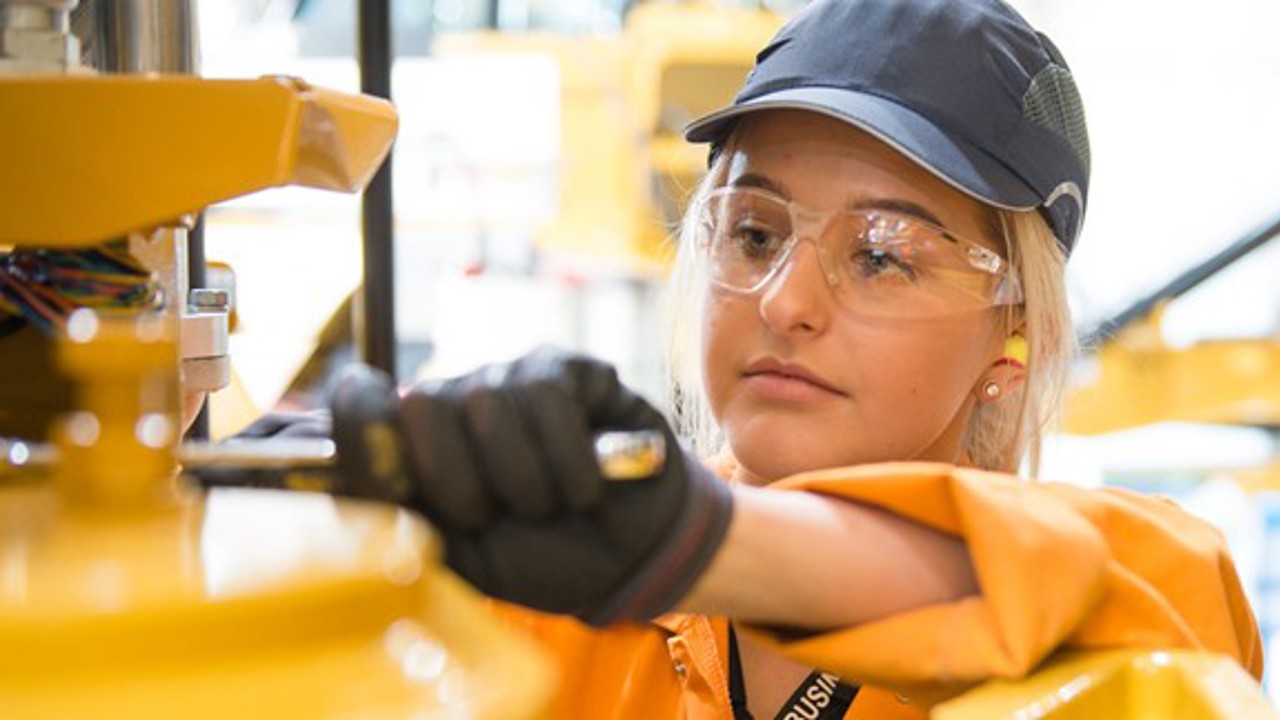 A female engineer working with machinery in protective clothing 