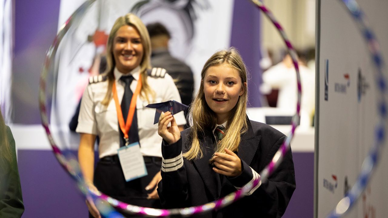 A pilot watches as student attempts to fly paper plane through obstacle course at The Big Bang Fair