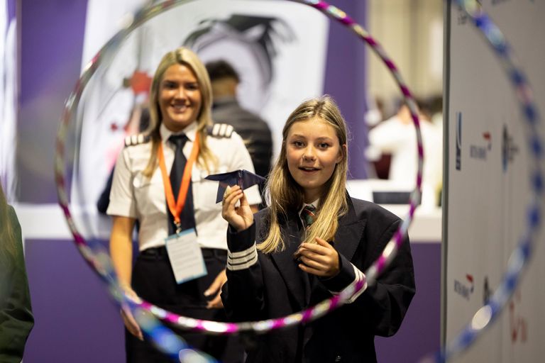 A pilot watches as student attempts to fly paper plane through obstacle course at The Big Bang Fair