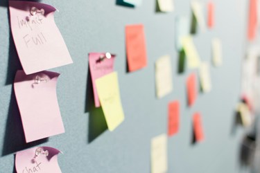 A group of colourful post it notes stuck on a wall