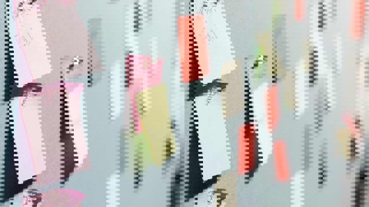 A group of colourful post it notes stuck on a wall