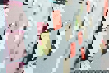 A group of colourful post it notes stuck on a wall