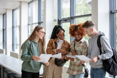 A group of young people look at results smiling and sharing