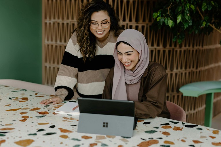 Two business professionals talking at a computer