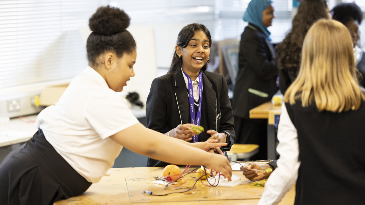 A group of girls laughing doing a science experiment