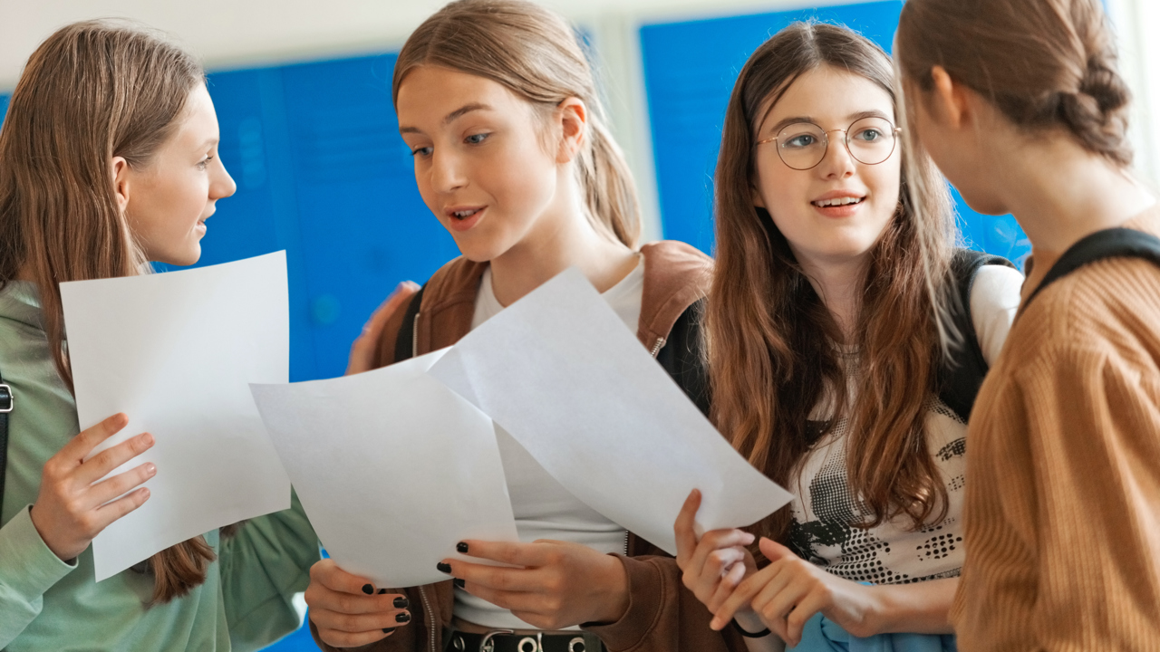 A group of young people look at their exam results