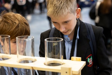 Young people interact with exhibits and stands and activities at The Big Bang Fair 