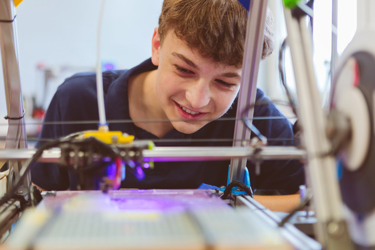 A young person watching a machine at work