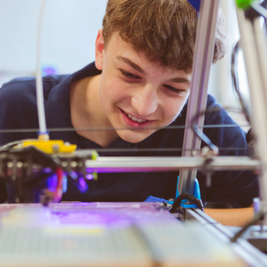 A young person watching a machine at work