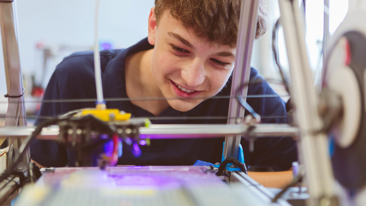 A young person watching a machine at work