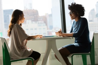 Business professionals talking at a table at their workplace