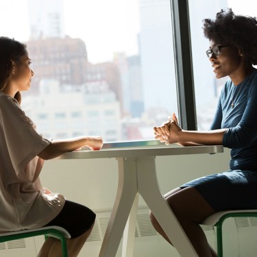 Business professionals talking at a table at their workplace